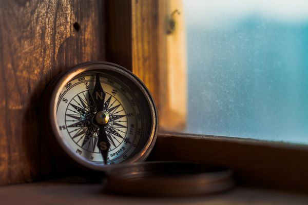 A picture of a compass in a window frame